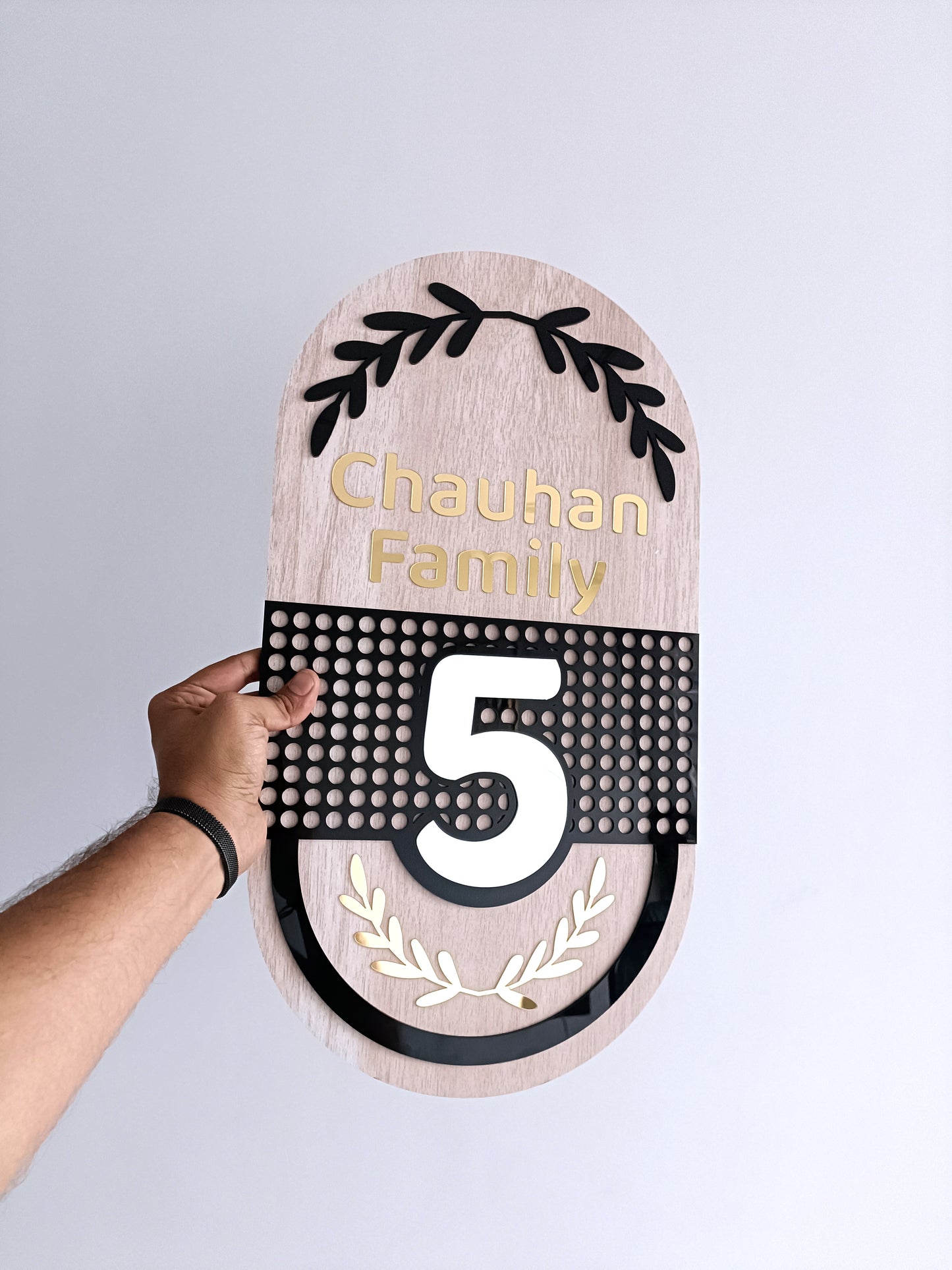 wooden door plaque with 'chauhan family' and number '5' on a gray background