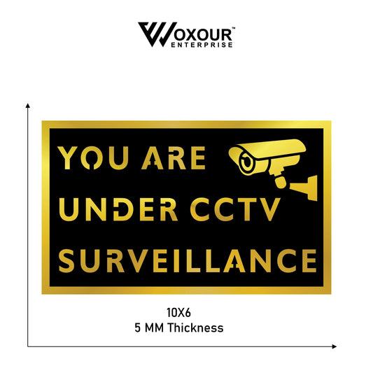 CCTV surveillance warning sign with camera icon and text 'YOU ARE UNDER CCTV SURVEILLANCE' on a black background, brand 'Woxour Enterprise' visible.