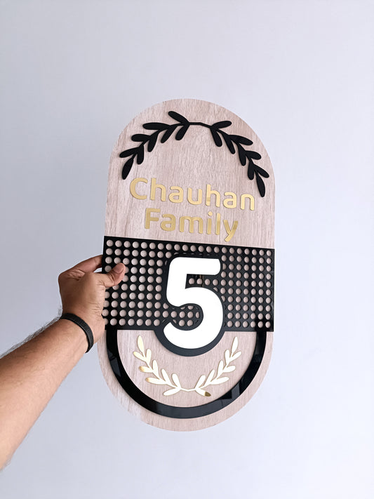 Wooden door plaque with 'Chauhan Family' and number '5' on a gray background