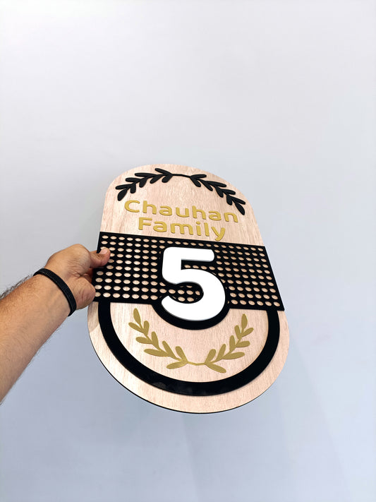 Wooden door plaque with 'Chauhan Family' and number '5' on a black background